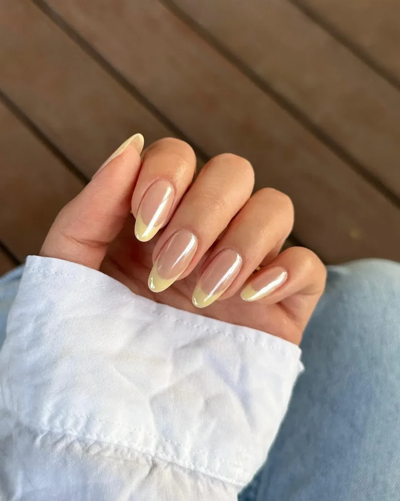 Chrome French Tip Nails 2026: 32 Designs and What to Tell Your Nail Tech 18 butter yellow chrome french tips on short almond nails with a sheer nude base