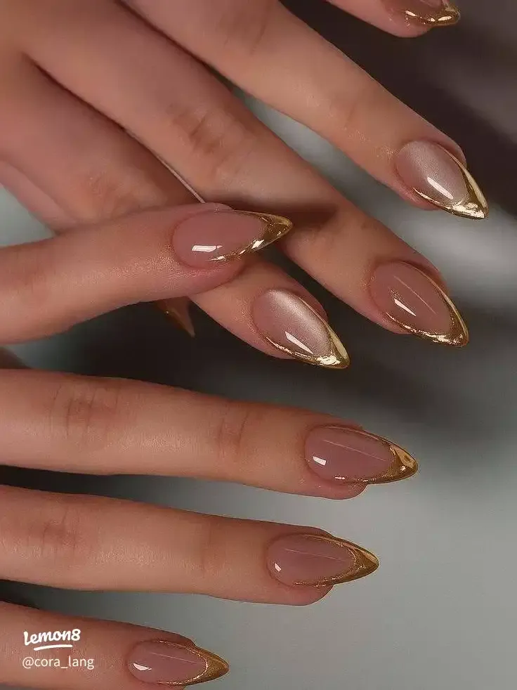 Chrome French Tip Nails 2026: 32 Designs and What to Tell Your Nail Tech 11 gold chrome french tips on almond nails with a warm nude base