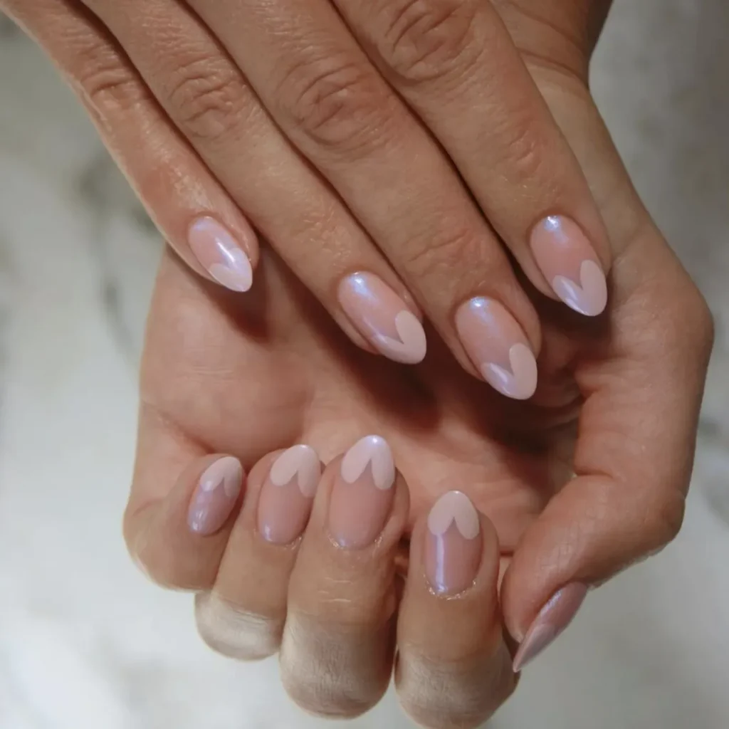 Chrome French Tip Nails 2026: 32 Designs and What to Tell Your Nail Tech 31 silver chrome heart shaped french tips on almond nails with a sheer pink base